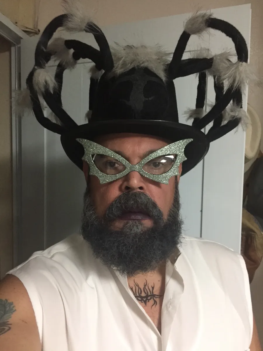 Wilfredo in a spider hat and glittered cat-eye glasses