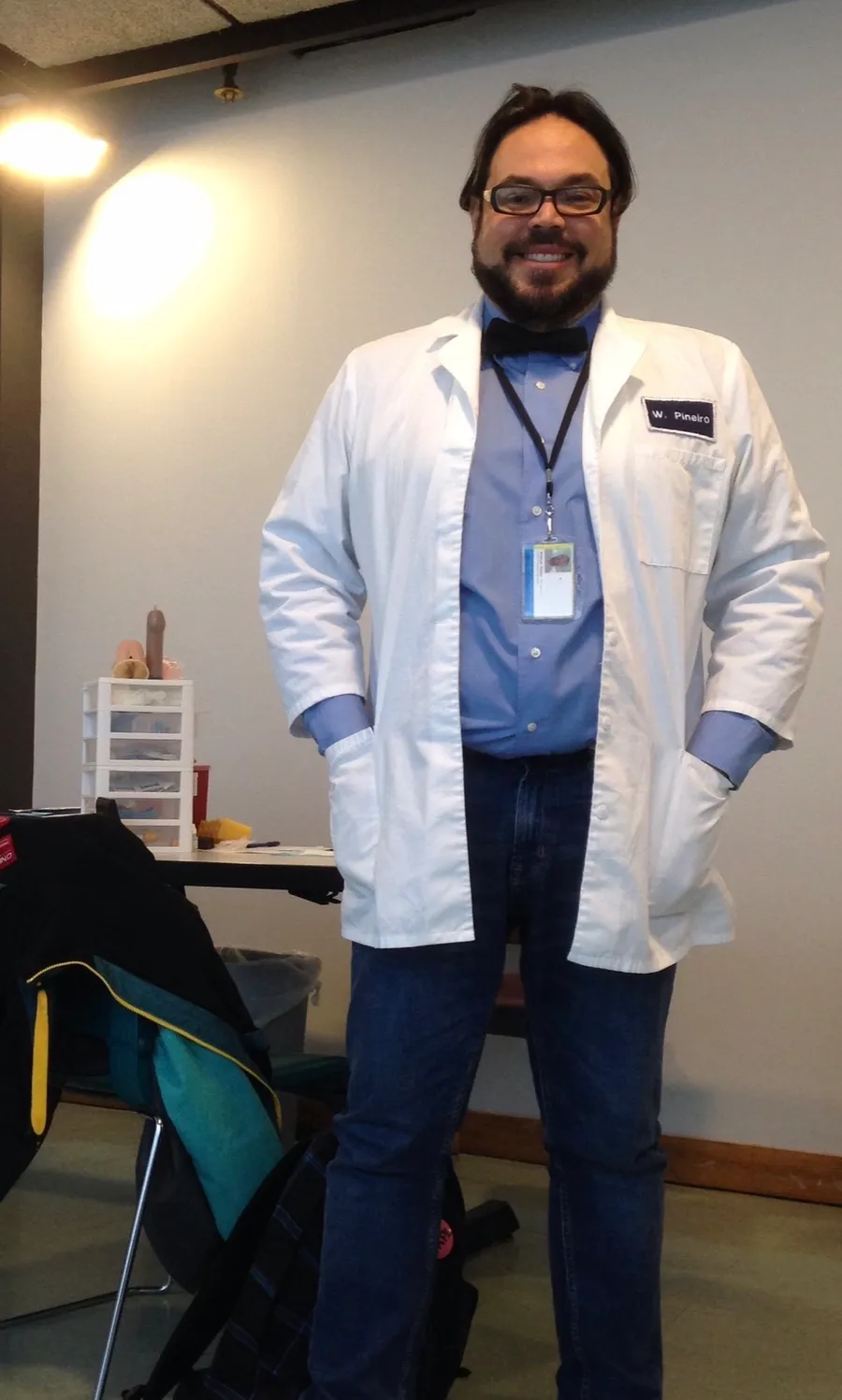 Wilfredo in a white coat labelled W. Piñeiro at a health-education workshop