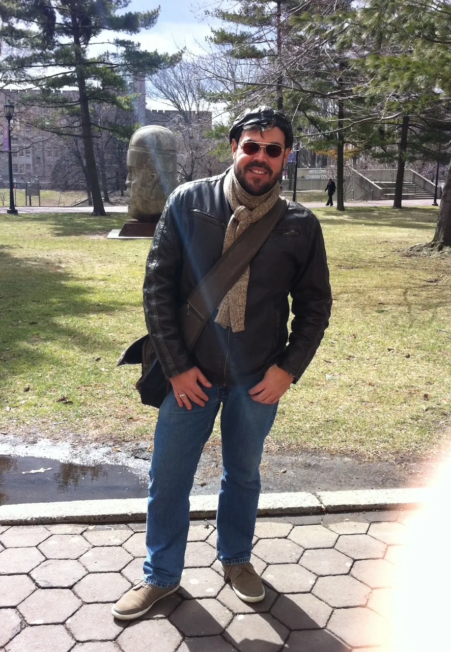 Wilfredo on the Lehman College campus in a leather jacket and scarf